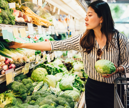 Woman in supermarket with fruit and vegetables