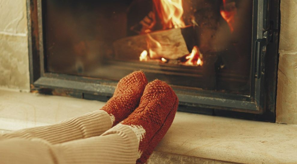 Feet warming by a fireplace